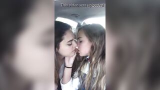 Two nymphets kissing in the car