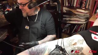 Marie Bossette touches herself while being tattooed