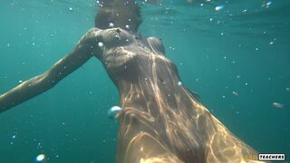 Nude model swims on a public beach in Russia.