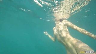 Nude model swims on a public beach in Russia.