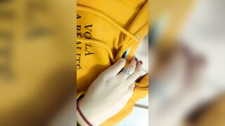 Home daytime striptease in a yellow hoodie. Close-up