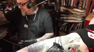 Marie Bossette touches herself while being tattooed