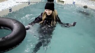 wetlook girl with winter clothes swims in the pool
