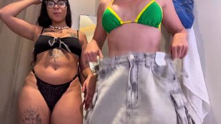 Friends secretly make out in the store's fitting room.